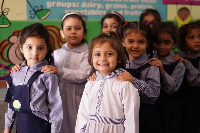 Farooqi Grammar School students smiling in a hallway